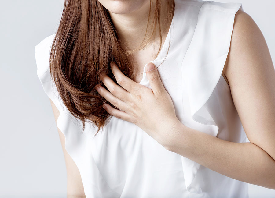胸を抑える女性